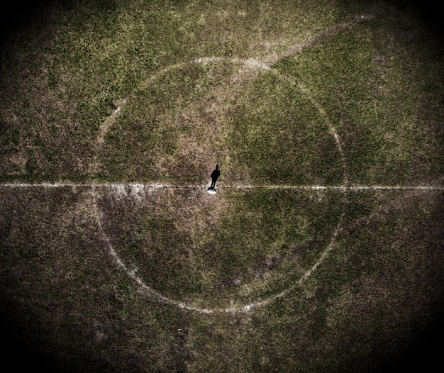 An overhead tactical view of a FIFA 25 match, showing a player positioned on the right wing, angling inwards towards the goal. Arrows indicate the optimal trajectory for a finesse shot towards the far post, avoiding defenders.