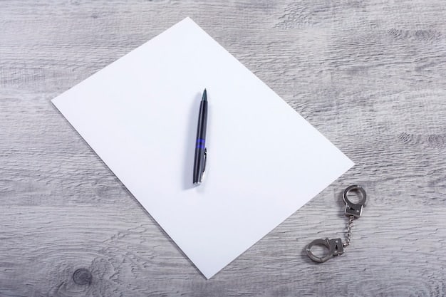 A close-up of a contract document with key clauses highlighted, a pen resting on top, and a law book subtly placed in the background, symbolizing the importance of legal understanding in contract negotiations.