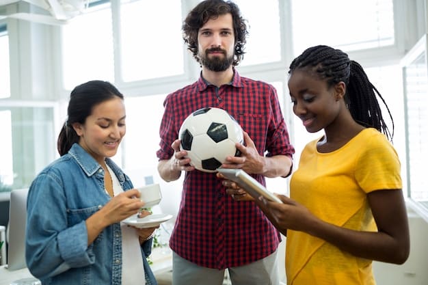 A US soccer player in a huddle with teammates and a coach, all looking attentive, symbolizing collaborative effort and teamwork in understanding and adhering to FIFA regulations.