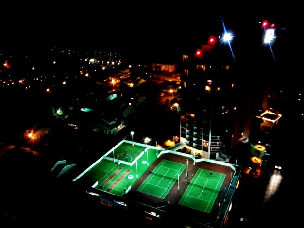 A bird's-eye view of a packed MLS soccer-specific stadium at night, with vibrant lights, an energetic crowd, and the pitch illuminated, emphasizing the modern American soccer experience.