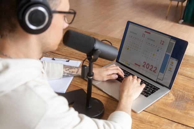 A podcast host with headphones, intensely focused on a laptop screen displaying MLS team logos and player statistics. A professional microphone is prominent on the desk.
