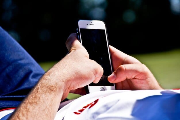 A close-up shot of a smartphone screen displaying social media feeds from US soccer accounts (e.g., MLS, NWSL official pages), surrounded by subtle motion blur indicating rapid content scrolling. The image should convey the immediacy and accessibility of information on mobile devices.