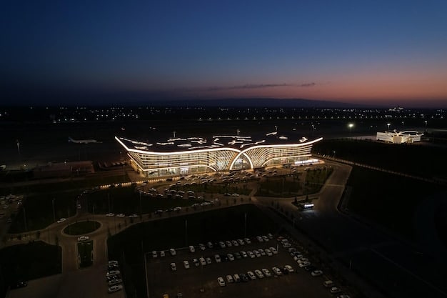 An aerial shot of SoFi Stadium in Los Angeles, California, illuminated at night, showcasing its futuristic design and capacity.