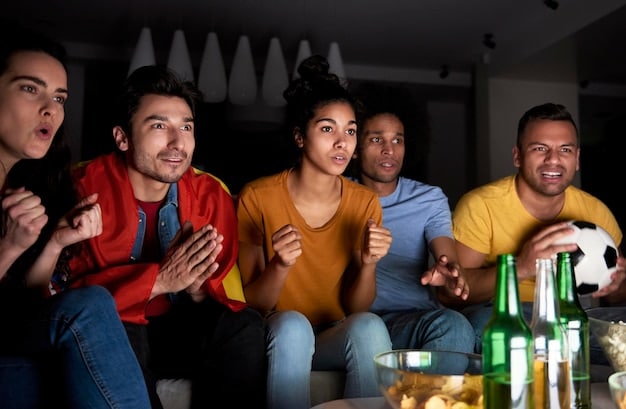 A diverse group of friends gathered around a large screen, passionately watching a football (soccer) match. Some are holding snacks, others are gesturing enthusiastically, and the overall atmosphere is one of shared excitement and camaraderie.