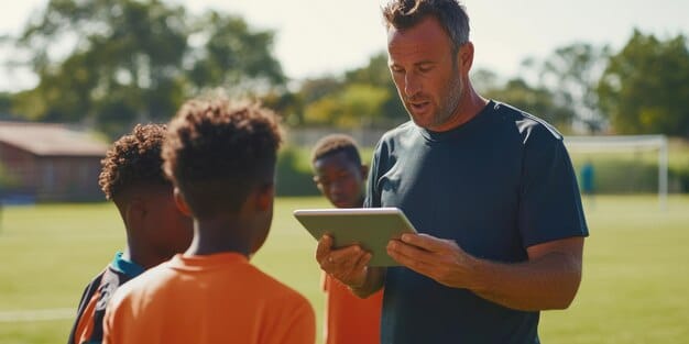 A diverse group of young soccer players training on a modern pitch, with a coach looking at a tablet displaying analytical data. The atmosphere is collaborative and forward-looking.