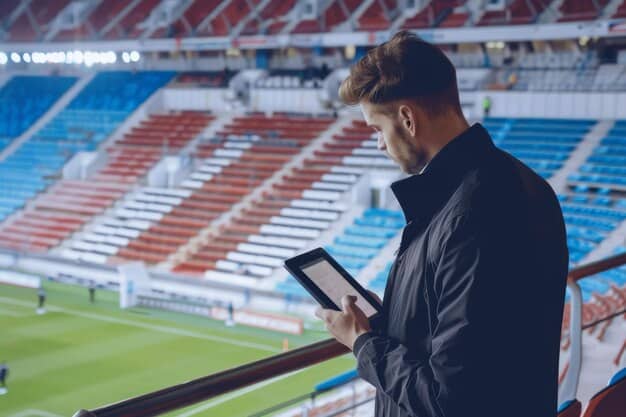 A soccer coach on the sidelines, looking intently at a tablet or screen, with a thoughtful expression. Represents strategic integration of VAR awareness.