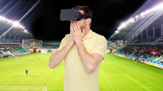 A fan wearing AR glasses, watching a soccer match with overlaid stats and player information appearing directly in their field of vision, enhancing their viewing experience from a home setting.