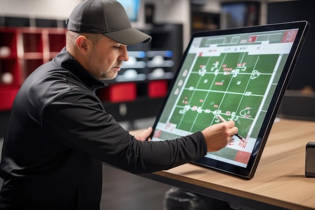 A coaching staff looking at a large touchscreen display showing real-time GPS data of soccer players during a training session