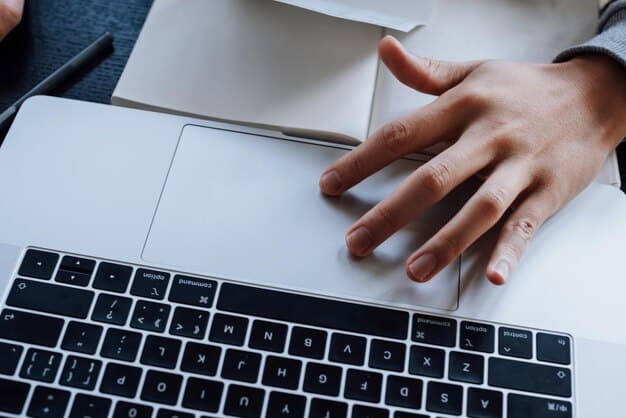 A close-up shot of a person's hands typing an email on a laptop, with a draft of a letter to a sports club official visible on the screen. The email expresses concerns about rising ticket prices and suggests alternative pricing models that would be more affordable for fans, aligning with the goal of 