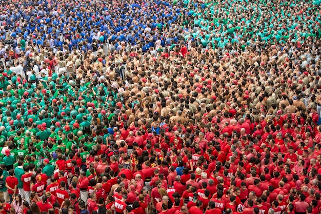 A wide shot of a diverse crowd of soccer fans in a stadium, with one person standing out and leading the chant with enthusiasm. They are waving their arms and shouting loudly. The crowd is following their lead, creating a unified and powerful sound. The image is related to leading the crowd during soccer chants, amplifying the 'The Art of the Chant: Learn the Most Popular US Soccer Chants and Lead the Crowd'.